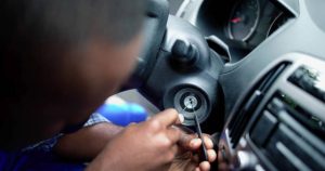 Automotive locksmith at work repairing car lock.