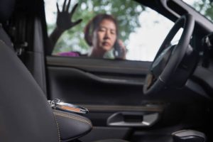 Senior Asian woman calling Car Key Pro after locking keys inside car.